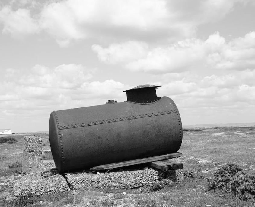 A black and white picture of an uneven storage tank