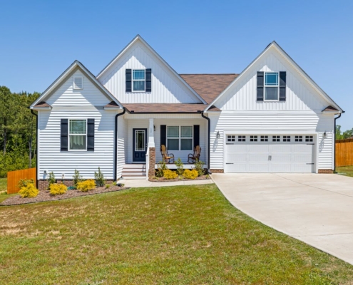 A picture of a beautiful home with a concrete driveway